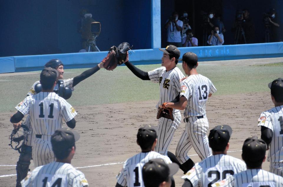 試合終了後、捕手とグラブタッチをするノースアジア大明桜・風間（右）