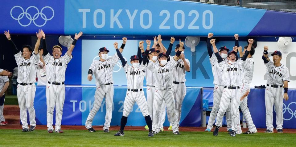 ８回、山田の勝ち越し３点二塁打に、総立ちでガッツポーズする日本ナイン＝横浜スタジアム