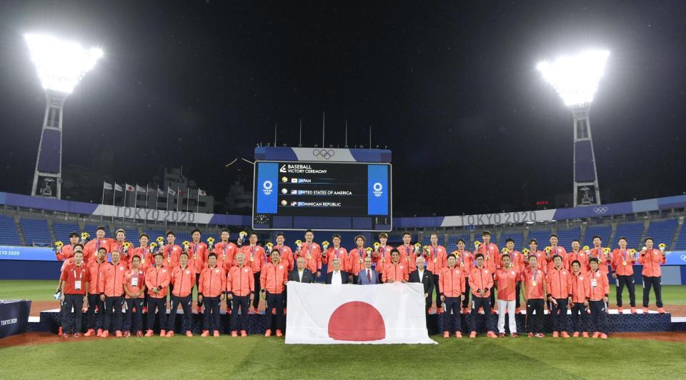 　金メダルを授与された表彰式を終え、日の丸を広げて記念撮影する日本チーム＝横浜スタジアム