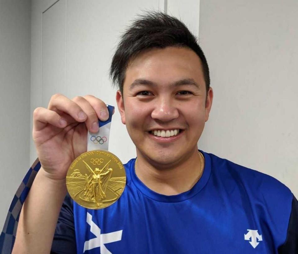 　東京五輪で獲得した金メダルを手に笑顔を見せる山崎（球団提供）
