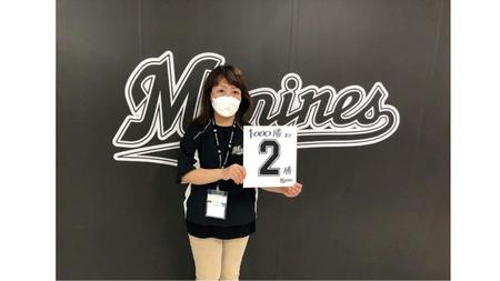 「１０００勝まて２勝」の色紙を持った場内アナウンス担当谷保恵美さん（球団提供）