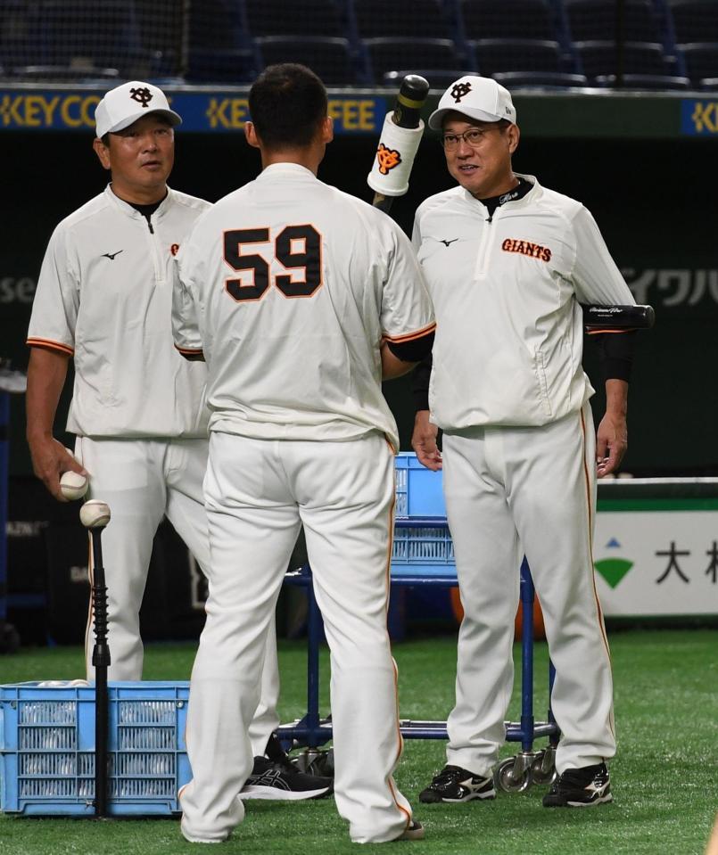 　背番号１０のユニホームが届くまで背番号５９のユニホームを借りて練習をする中田（手前）に声をかける原監督（右）。左は吉村コーチ