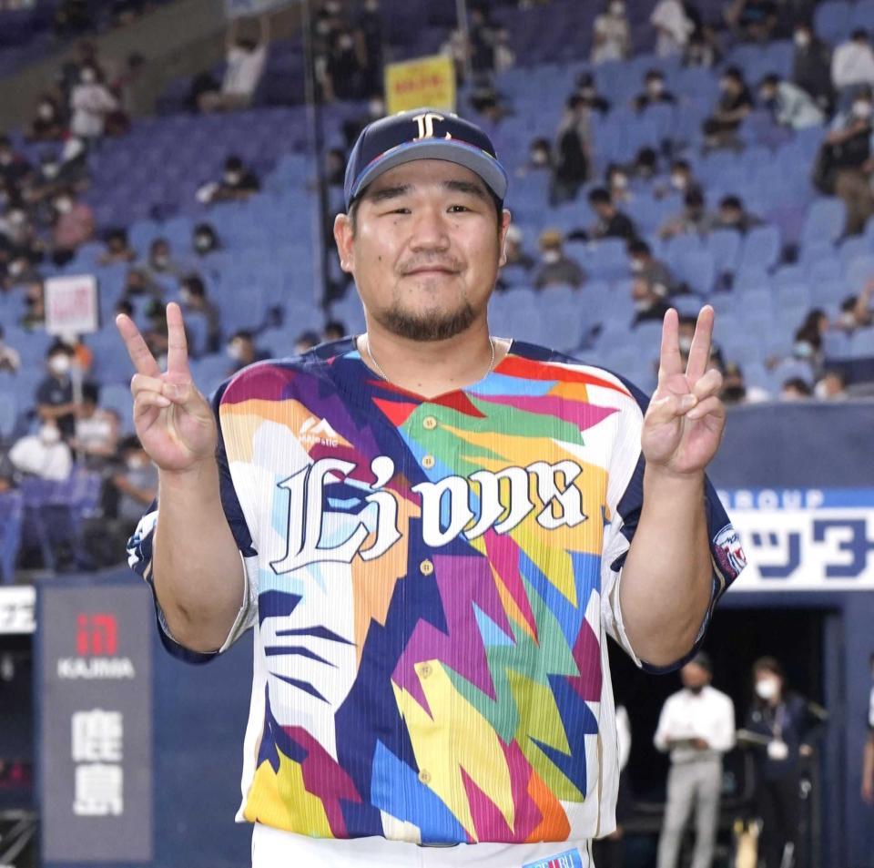 　笑顔で通算満塁本塁打数の２２を示す中村