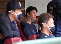 　雨のグラウンドを見つめる山本