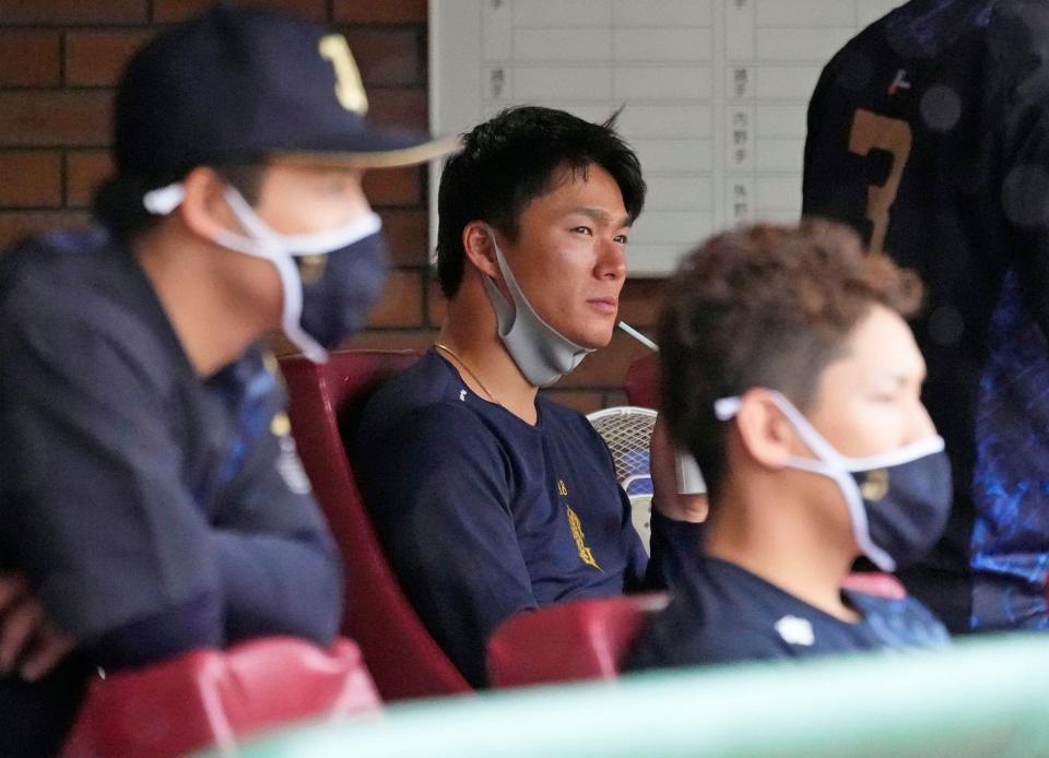 　雨のグラウンドを見つめる山本