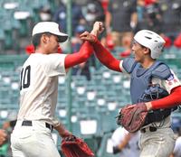 　完投勝利を挙げ、タッチを交わす智弁学園・小畠（左）＝撮影・北村雅宏