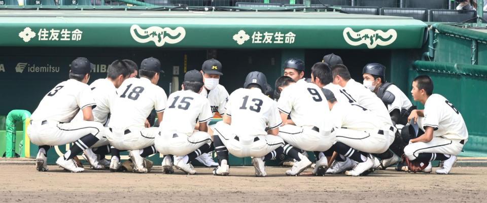 　９回の守備を終えたナインに座って話しかける松商学園・足立監督（左から５人目）＝撮影・高石航平