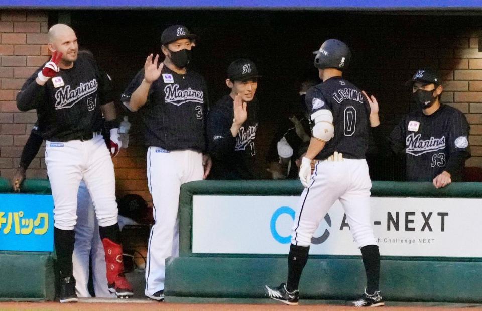 　１回、先頭打者本塁打を放った荻野（０）を迎える佐々木朗（左隣）らロッテナイン