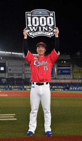 　今季５勝目を挙げチームの１０００勝（千葉移転後）達成のボードを掲げ笑顔の美馬（撮影・開出牧）