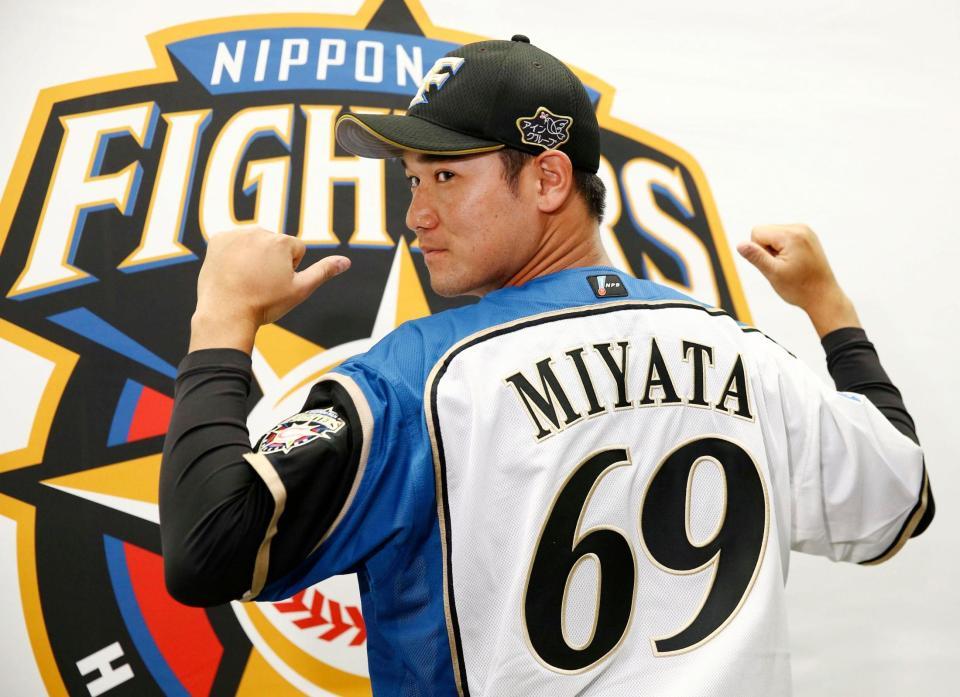 　支配下選手契約を結び、ポーズをとる宮田