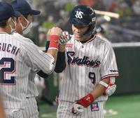 １回、先頭打者本塁打を放ち、ナインに迎えられる塩見＝東京ドーム