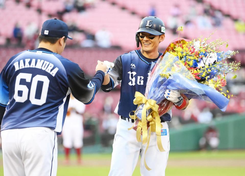 ９回、通算２０００安打を達成して中村（左）から花束を受け取る西武・栗山＝楽天生命パーク（撮影・堀内翔）