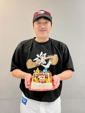 報道陣から贈られた誕生日ケーキを持って、笑顔の石井監督＝楽天野球団提供
