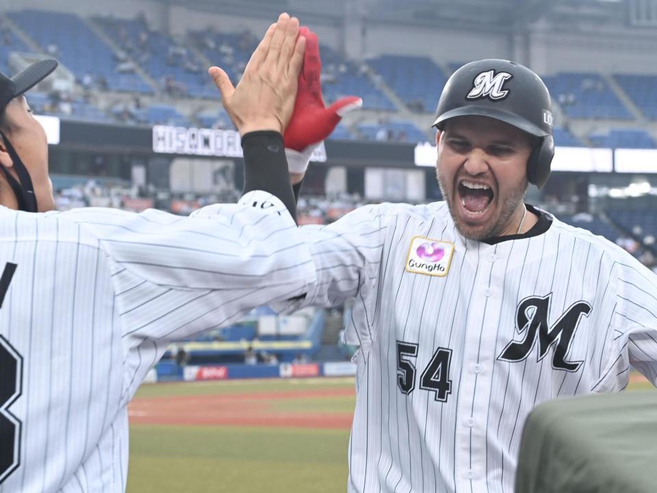 ３回、２ランを放ちロッテ・三木（左）と満面の笑みでタッチをかわすロッテレアード＝ＺＯＺＯマリンスタジアム（撮影・高石航平）