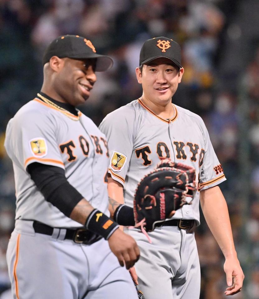 　２回裏を終え、ウィーラー（左）と談笑しながらベンチに戻る菅野