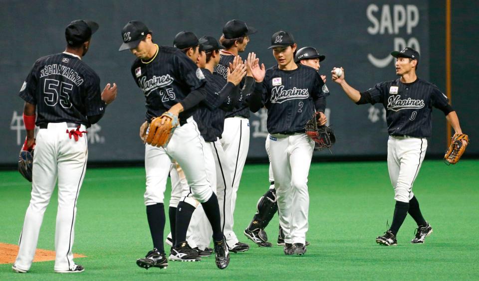 　日本ハムに連勝し、タッチを交わすロッテナイン＝札幌ドーム