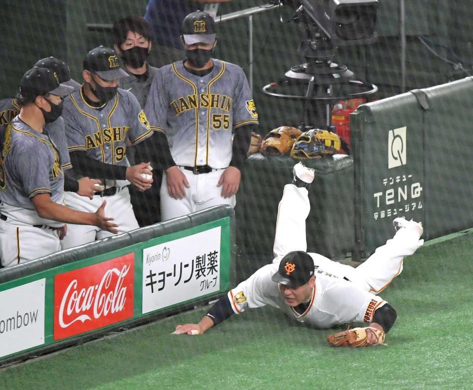 　５回、中野の打球を追うも捕球し損ね、倒れる三塁手・岡本和（撮影・西岡正）