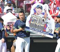 通算５００試合登板を達成し、記念のボードを掲げるヤクルト・石川（撮影・高部洋祐）