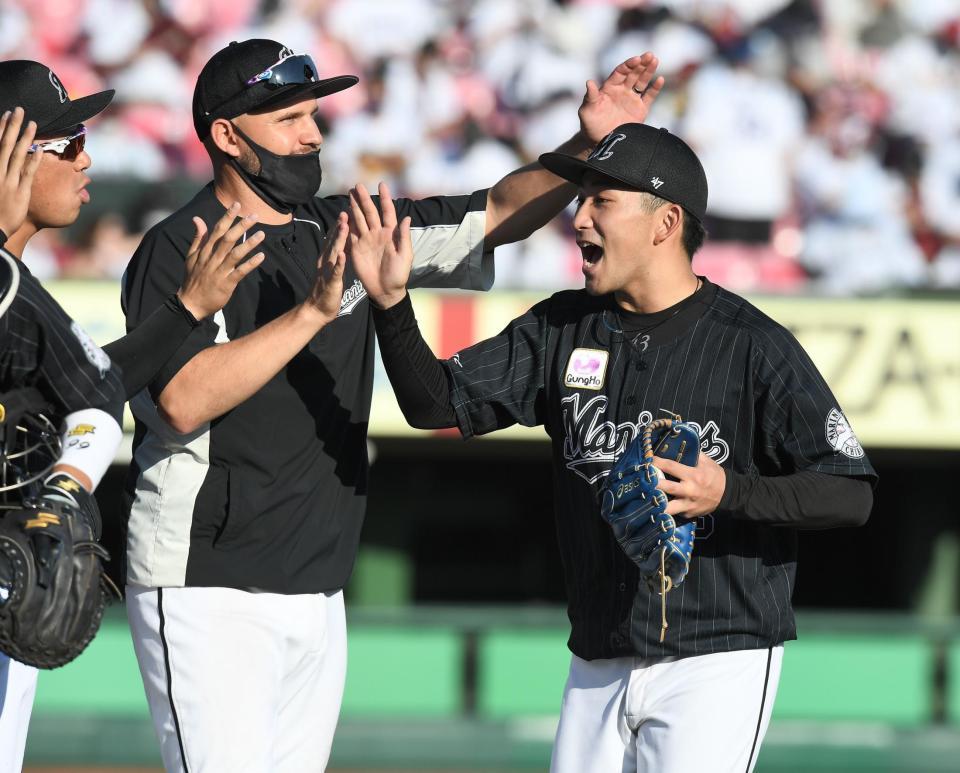　完封で１０勝目を挙レアードらナインに迎えられる小島（撮影・金田祐二）
