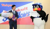 つば九郎から筆談でねぎらわれ、笑顔を見せる雄平（代表撮影）＝都内の球団事務所