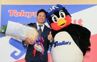 つば九郎からねぎらわれ、笑顔でポーズを決める雄平（代表撮影）＝都内の球団事務所