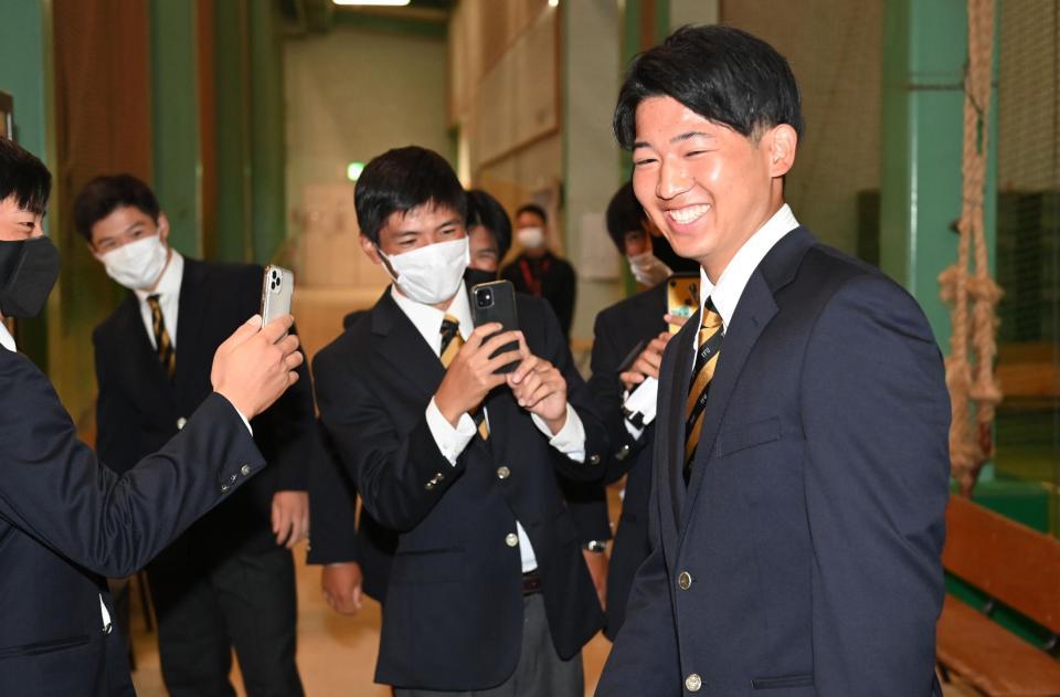 　オリックスに１位で指名が決まり、親友に記念撮影され笑顔を見せる東北福祉大・椋木蓮（右）＝撮影・高石航平