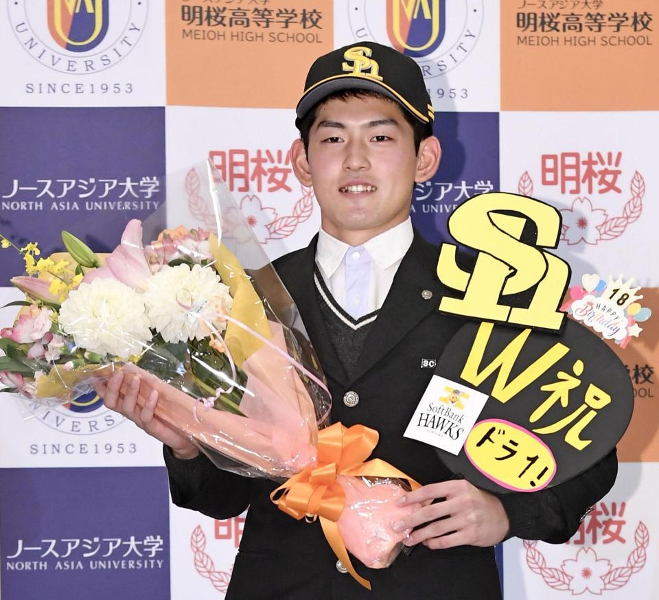　ソフトバンクから１位指名を受け、花束を手に笑顔を見せるノースアジア大明桜高の風間球打投手