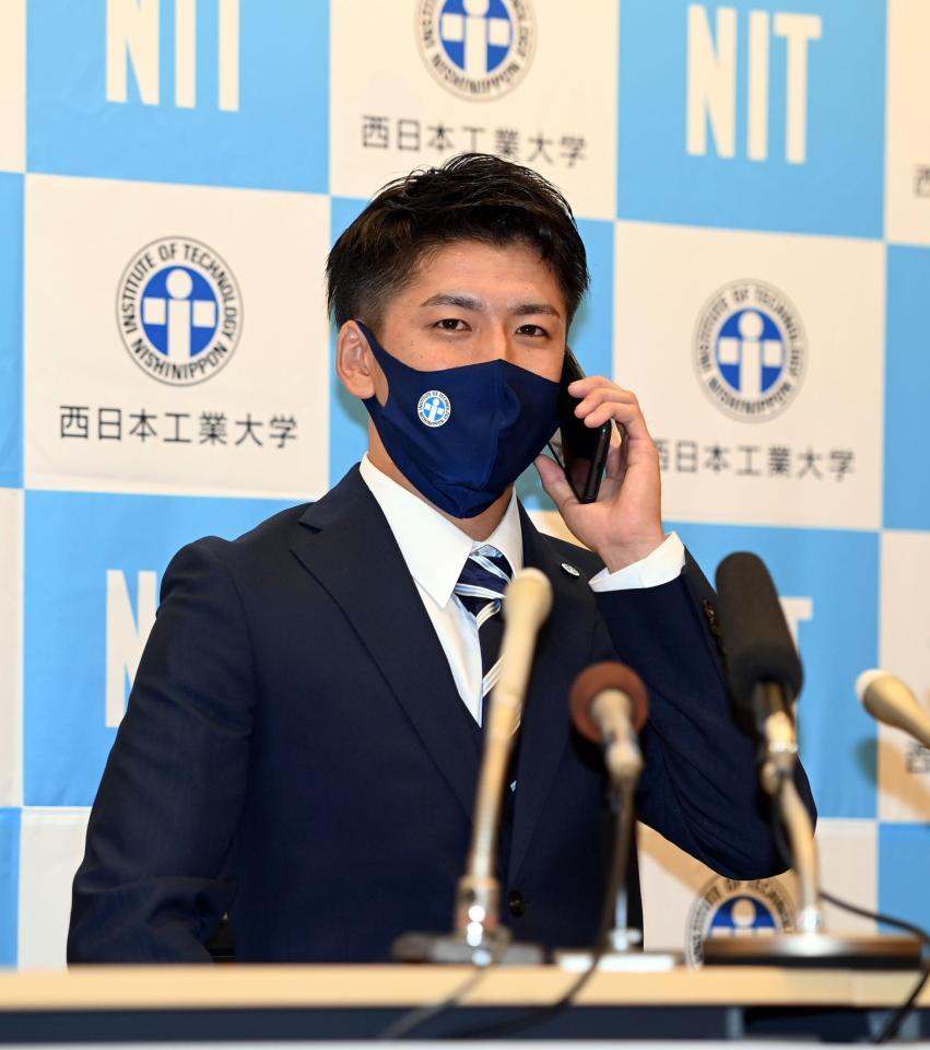 　西日本工大・隅田知一郎は西武から１位指名され、球団関係者からの電話を受ける（撮影・山口登）