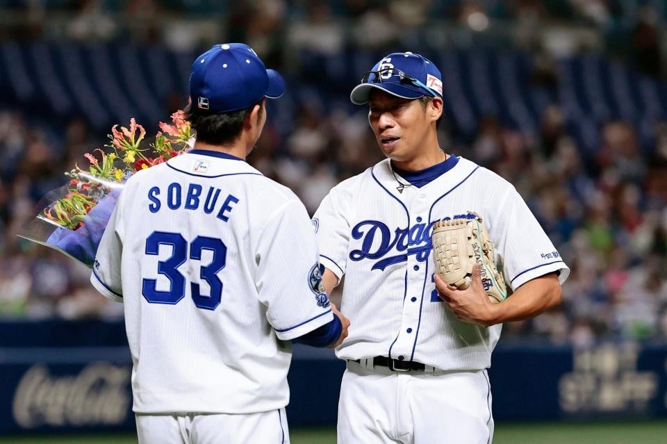 　１回、引退試合の登板を終え、祖父江（左）から花束を受け取る中日・山井＝バンテリンドーム