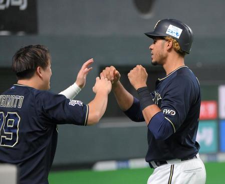 　８回、交代してベンチ前で杉本（左）に迎えられるモヤ（撮影・堀内翔）