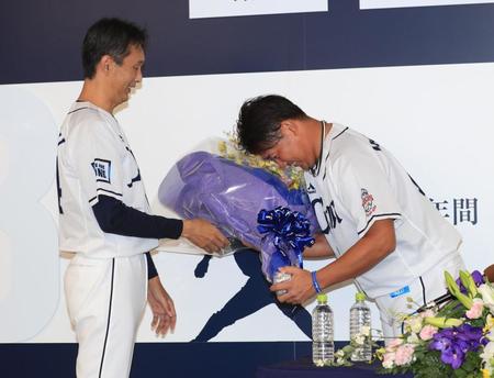 　引退会見の後、西口コーチ（左）から花束を受け取る松坂