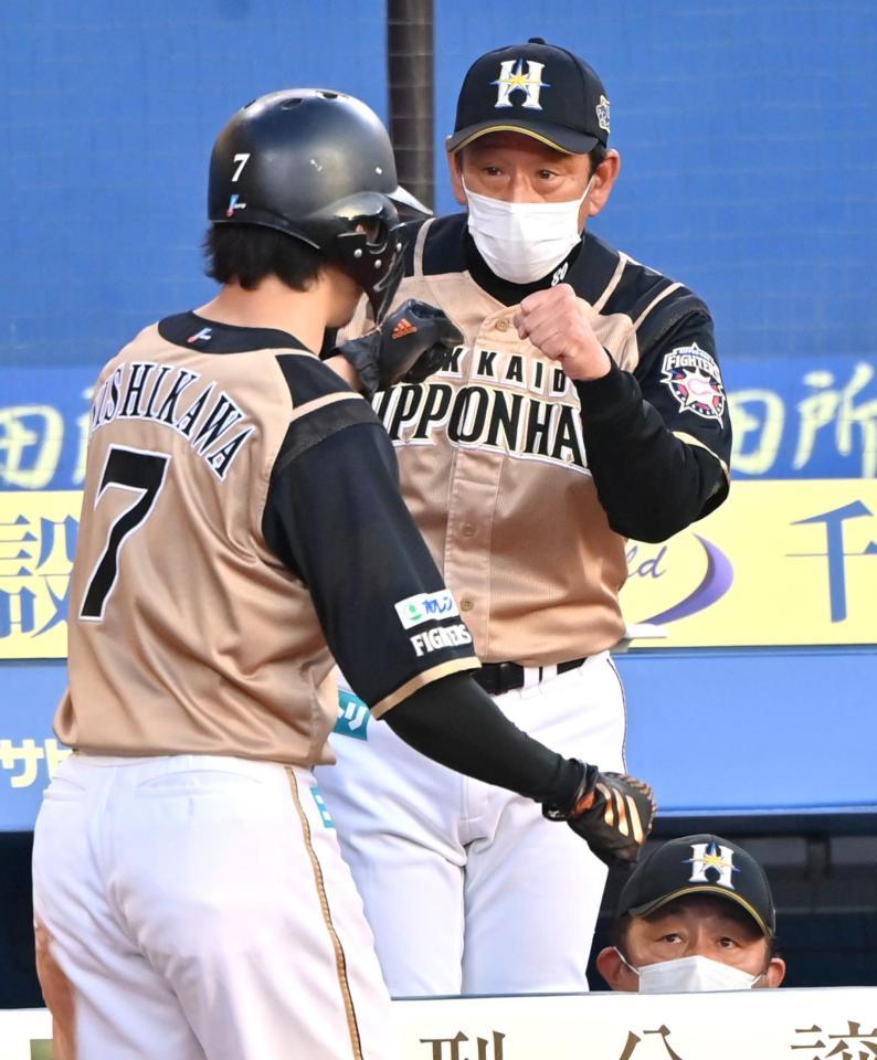 　７回、代打・王柏融の適時二塁打で生還した二走西川（左）を迎える日本ハム・栗山監督