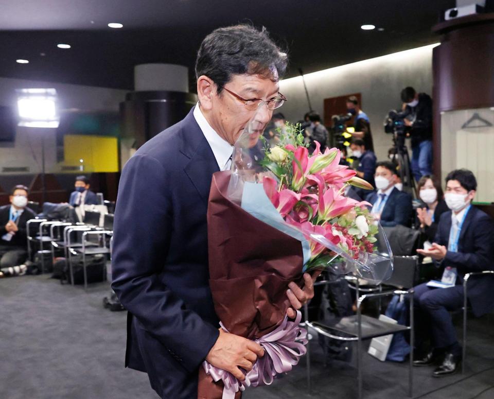 　退任の記者会見を終え、花束を手に引き揚げる栗山監督