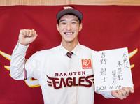 楽天入団が決まり、色紙を手に笑顔でポーズをとる昌平高の吉野創士外野手（球団提供）