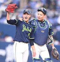 完封勝利を挙げ、グラブを突き上げるヤクルト・高橋（左）と中村