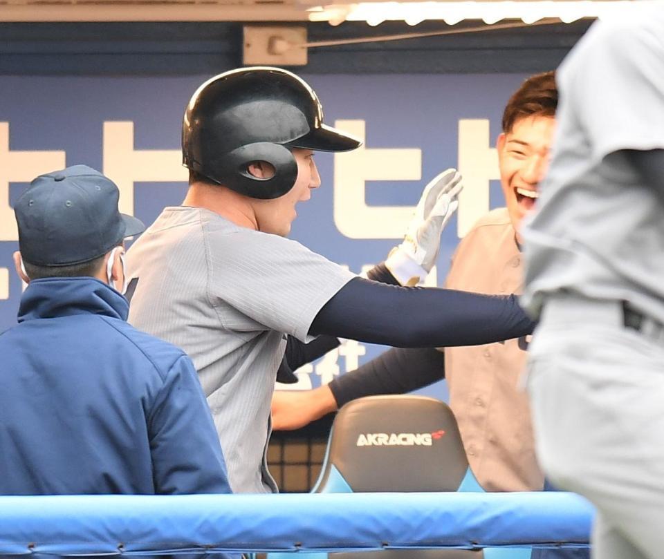 ２回、右越えに先制ソロを放ち、　ナインとタッチを交わす慶大・正木智也（撮影・西岡正）