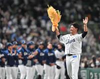 　イチローから渡された花束を持ち、ファンに向かって手を振る松坂大輔（撮影・西岡正）