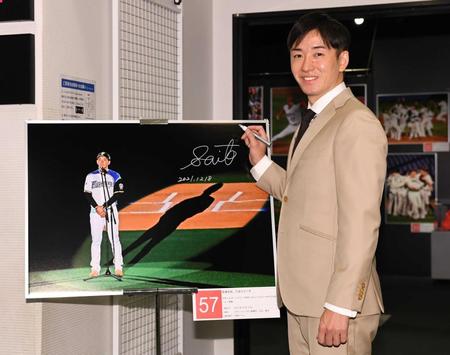 　自身の引退セレモニーの写真にサインを入れ笑顔の斎藤佑樹氏（撮影・金田祐二）