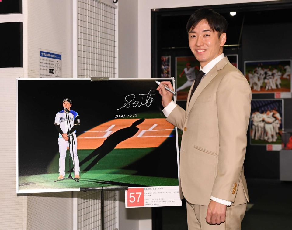 　自身の引退セレモニーの写真にサインを入れ笑顔の斎藤佑樹氏（撮影・金田祐二）