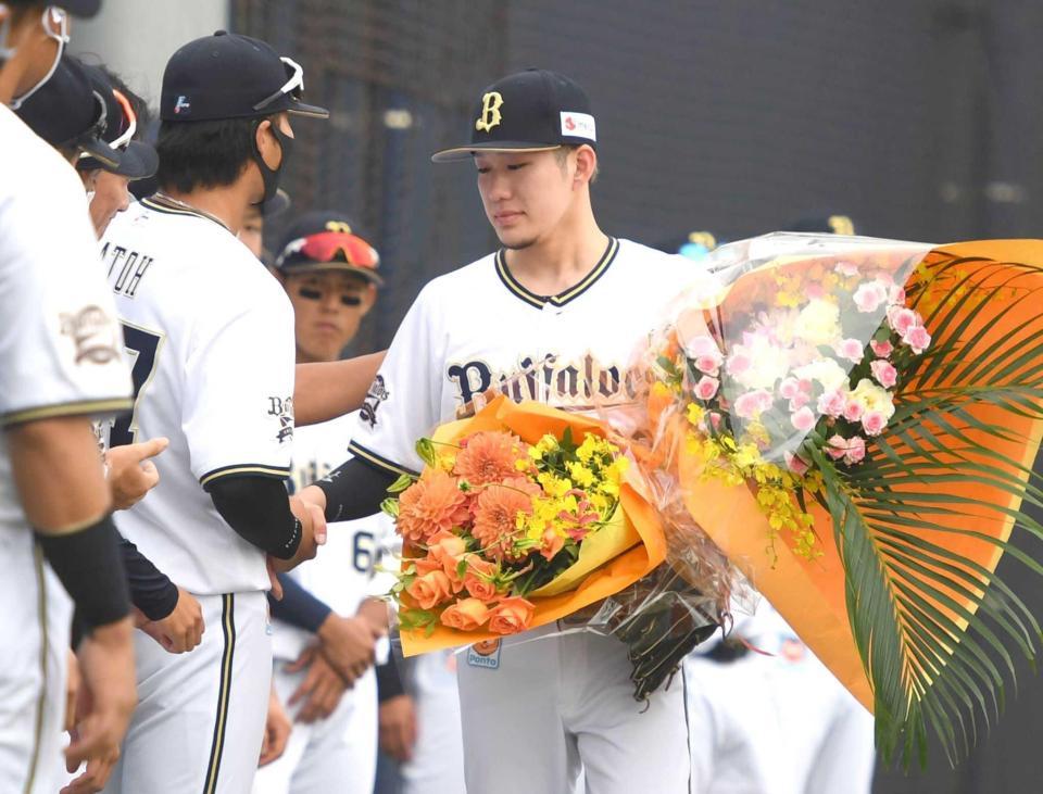 　引退試合で花束を手にナインに迎えられる西浦＝９月２８日、舞洲