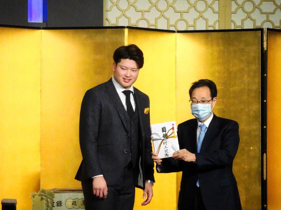 　熊本市内で行われた祝賀会で義援金の目録を手渡す村上