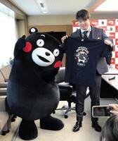 　くまモンにお願いされ、コラボＴシャツにサインした村上（右）、喜ぶくまモン（左）