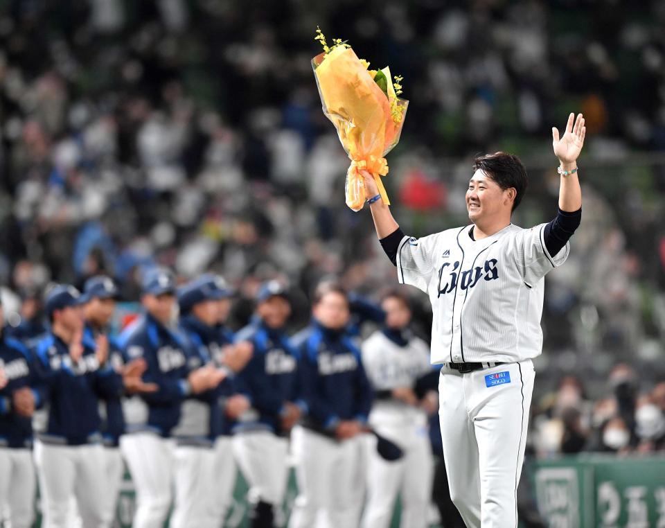 　イチロー氏から渡された花束を持ち、ファンに向かって手を振る松坂