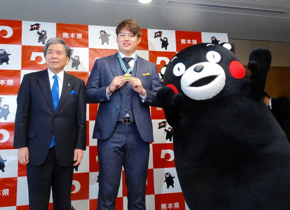 　熊本の愛されマスコット・くまモンから、特製「くまモン金メダル」をもらった村上（中央）