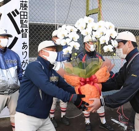 　花を贈られ祝福される東洋大姫路・藤田監督（左）