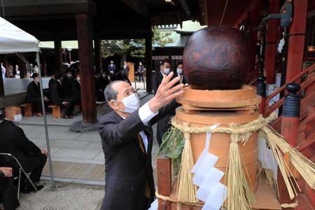 　筥崎宮に必勝祈願に訪れ、幸運をもたらすとされる木製の玉に触れる王会長（球団提供）