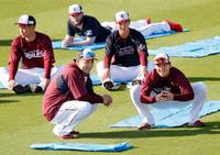 キャンプ初日、ウオーミングアップしながら松井裕（右）と談笑する楽天・田中将＝金武