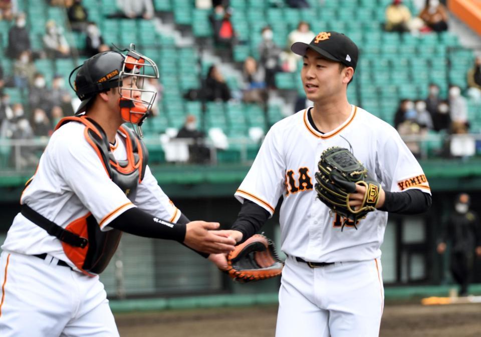 ２回を無安打無得点に抑え、岸田行倫（左）に迎えられる巨人・山崎伊織＝沖縄セルラースタジアム那覇（撮影・佐藤厚）