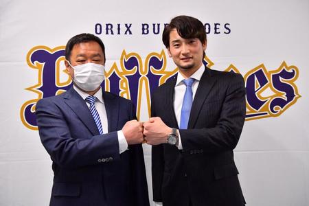 　福良淳一ＧＭ（左）と握手する育成選手として契約した中村勝