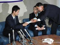 　ヒルマン監督からのメッセージを今成スカウト（右）から受け取る東北高・ダルビッシュ＝２００４年１１月